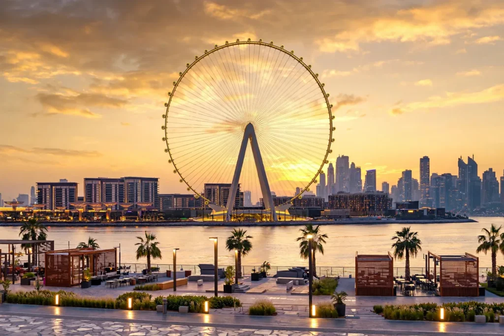 Things to do in Bluewaters Island Dubai: Ain Dubai observation wheel glowing at sunset over the island waterfront with the Dubai Marina skyline behind