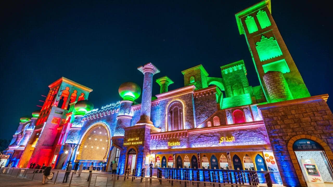 Ticket booths glowing at the entrance of Global Village Dubai at night, one of the biggest dubai events of the winter season