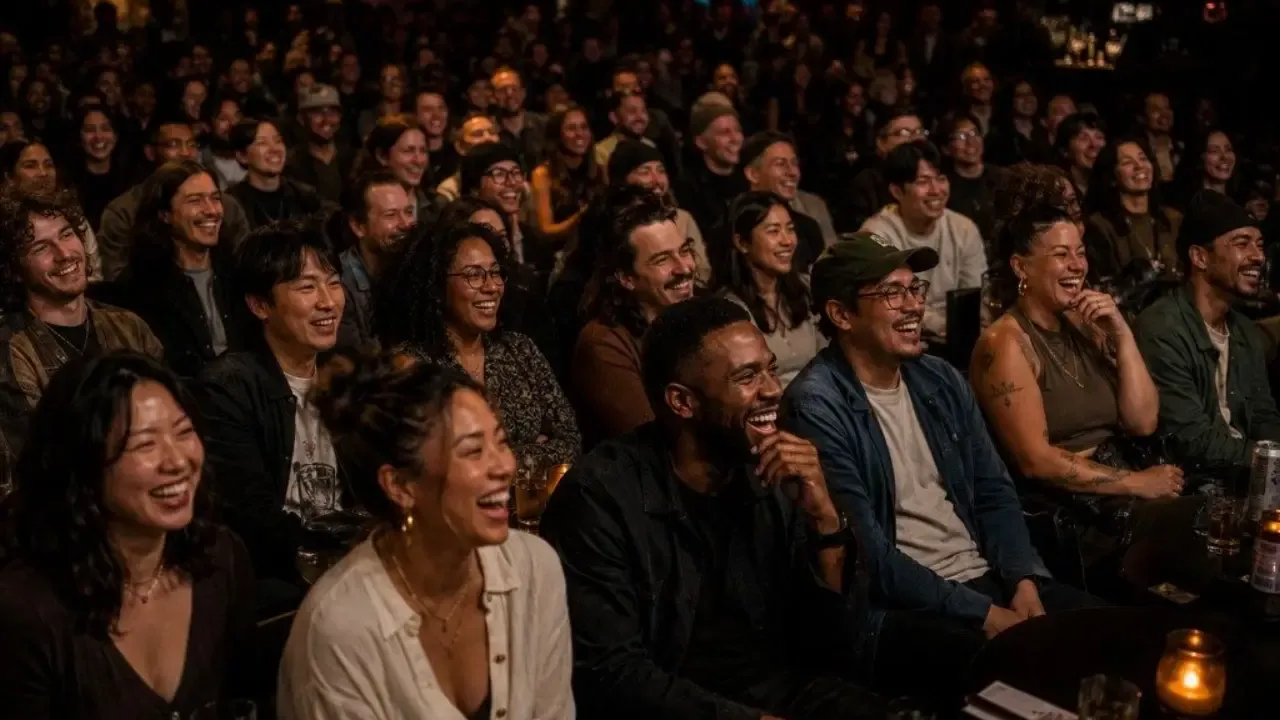 A packed comedy festival crowd laughing during a live stand-up show