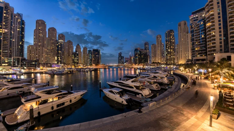 Hotels in Dubai Marina at dusk: waterfront towers and yachts along the marina promenade