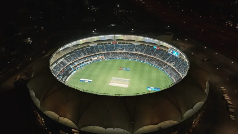 Dubai International Cricket Stadium lit up at night in Dubai Sports City