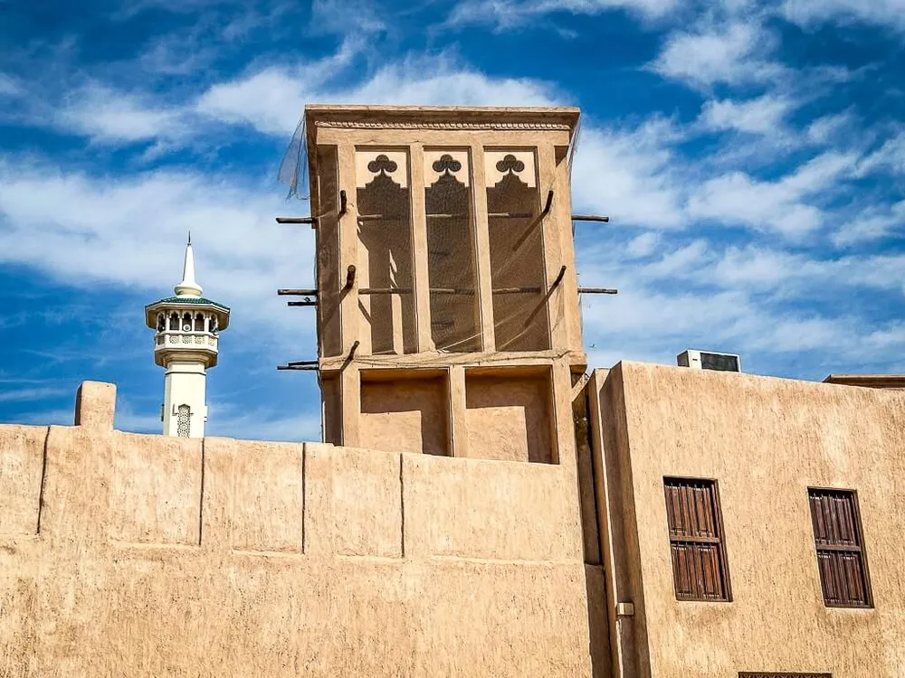 Wind tower rising above a restored coral-stone house in Al Fahidi Historical Neighbourhood, Bur Dubai
