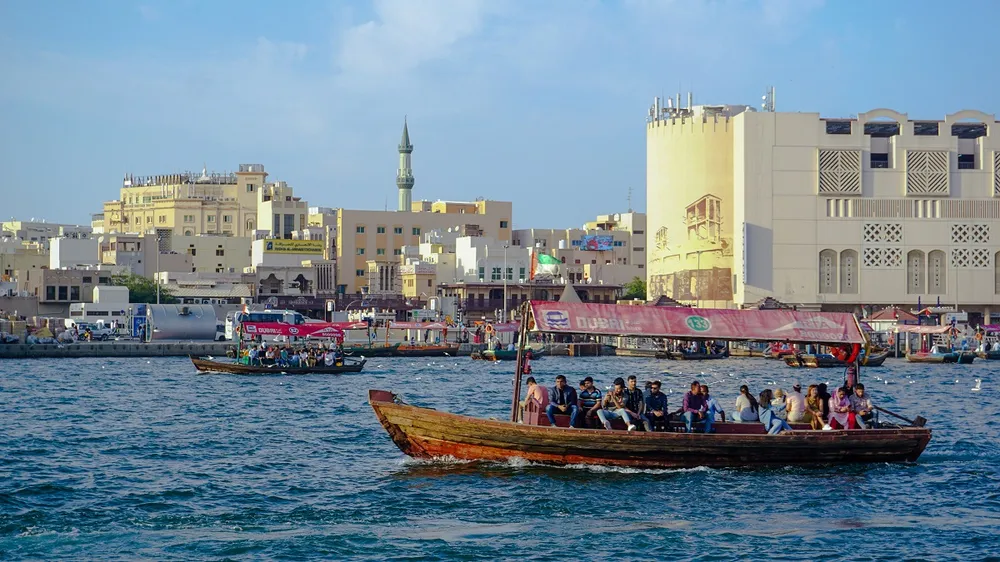 Wooden abras full of passengers crossing Dubai Creek between Bur Dubai and Deira