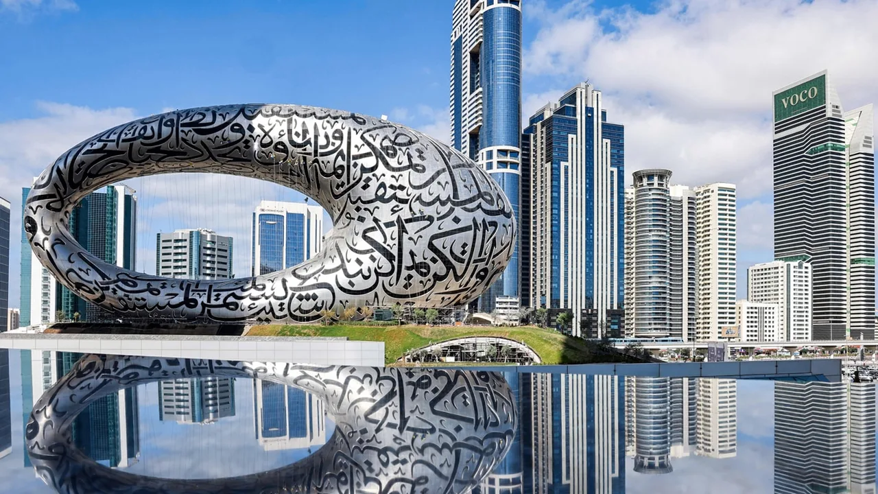The Museum of the Future's Arabic calligraphy facade reflected in the water feature outside the building.
