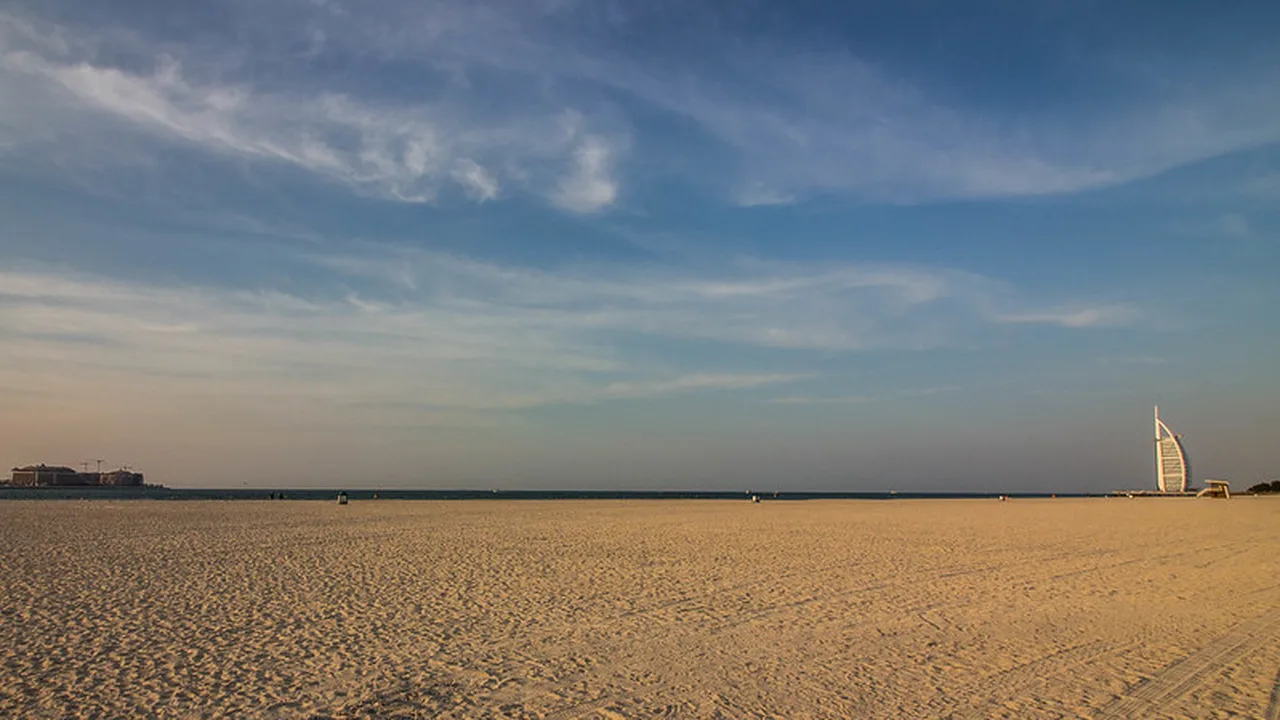 Calm shallow water at Secret Beach Dubai with Palm Jumeirah skyline